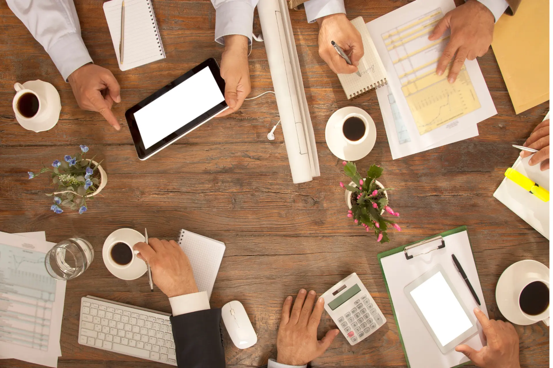 Mesa de trabalho vista de cima com anotações, tablet e materiais de estudo